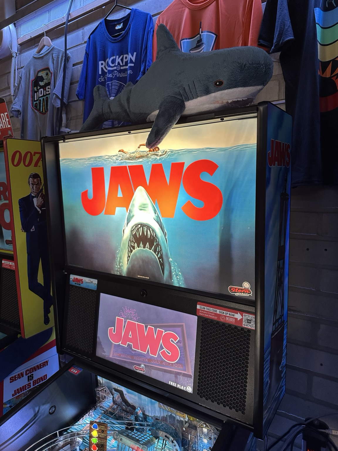 Jaws pinball machine, with a Blåhaj on top of its backbox.